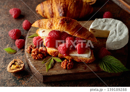 Croissant with camembert cheese, raspberries and walnuts. Croissant with camembert cheese, raspberries and walnuts. 139189288