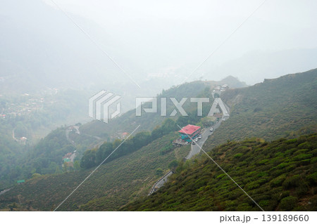 Winding mountain road passing through tea gardens in the misty Himalayan hills at Kurseong Winding mountain road passing through tea gardens in the misty Himalayan hills at Kurseong 139189660