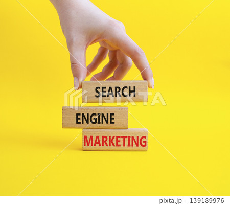 Search Engine Marketing symbol. Wooden blocks with words Search Engine Marketing. Businessman hand. Beautiful yellow background. Business and Search Engine Marketing concept. Copy space. Search Engine Marketing symbol. Wooden blocks with words Search Engine Marketing. Businessman hand. Beautiful yellow background. Business and Search Engine Marketing concept. Copy space. 139189976