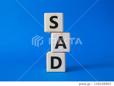 Sad symbol. Wooden cubes with words Sad. Beautiful blue background. Business and Sad concept. Copy space. Sad symbol. Wooden cubes with words Sad. Beautiful blue background. Business and Sad concept. Copy space. 139189993