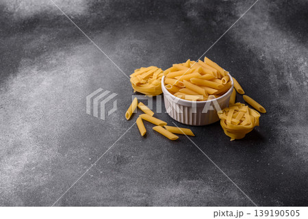 Italian uncooked dry penne regate pasta ready for cooking. Dry penne pasta Italian uncooked dry penne regate pasta ready for cooking. Dry penne pasta 139190505