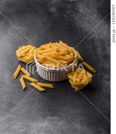 Italian uncooked dry penne regate pasta ready for cooking. Dry penne pasta Italian uncooked dry penne regate pasta ready for cooking. Dry penne pasta 139190507
