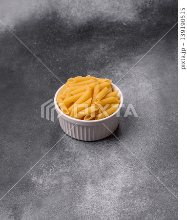 Italian uncooked dry penne regate pasta ready for cooking. Dry penne pasta Italian uncooked dry penne regate pasta ready for cooking. Dry penne pasta 139190515