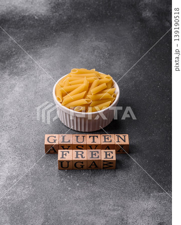 Italian uncooked, dry, gluten free penne pasta, ready for cooking. Dry, gluten free penne pasta 139190518