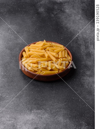 Italian uncooked dry penne regate pasta ready for cooking. Dry penne pasta Italian uncooked dry penne regate pasta ready for cooking. Dry penne pasta 139190528