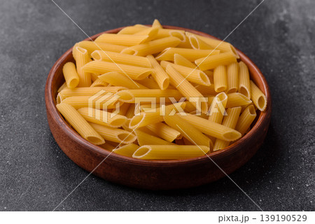 Italian uncooked dry penne regate pasta ready for cooking. Dry penne pasta 139190529