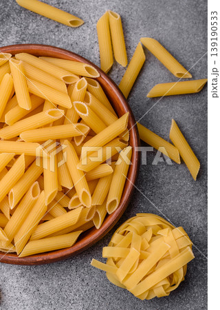 Italian uncooked dry penne regate pasta ready for cooking. Dry penne pasta Italian uncooked dry penne regate pasta ready for cooking. Dry penne pasta 139190533