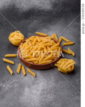 Italian uncooked dry penne regate pasta ready for cooking. Dry penne pasta Italian uncooked dry penne regate pasta ready for cooking. Dry penne pasta 139190536