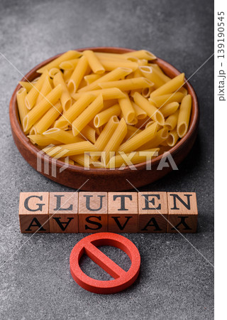 Italian uncooked dry penne regatta pasta with a gluten prohibition sign. The gluten prohibition sign Italian uncooked dry penne regatta pasta with a gluten prohibition sign. The gluten prohibition sign 139190545