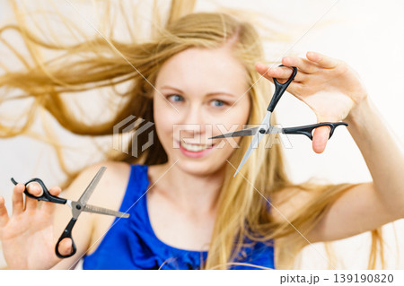 Young woman with scissors for haircutting Young woman with scissors for haircutting 139190820