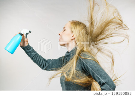 Girl messy hair holding spray bottle 139190883