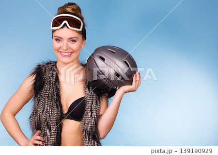 Woman wearing bra and holding ski helmet Woman wearing bra and holding ski helmet 139190929