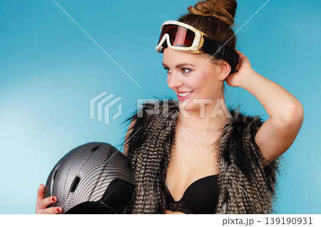 Woman seductive girl in ski googles holds helmet Woman seductive girl in ski googles holds helmet 139190931