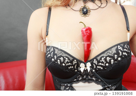 Woman wearing lingerie holding chilli pepper Woman wearing lingerie holding chilli pepper 139191008