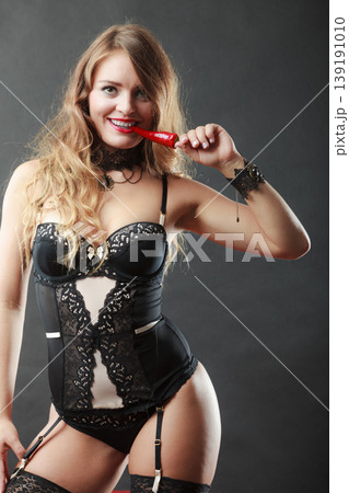 Woman wearing sexy lingerie holding chilli pepper Woman wearing sexy lingerie holding chilli pepper 139191010