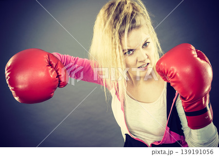 Angry woman wearing boxing gloves Angry woman wearing boxing gloves 139191056