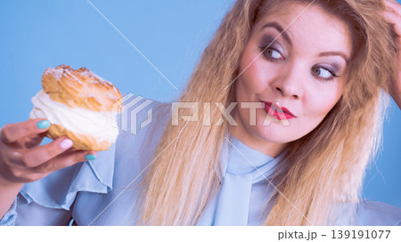 Funny woman holds cream puff cake Funny woman holds cream puff cake 139191077