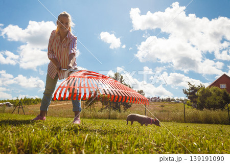 Unusual angle of woman raking leaves 139191090