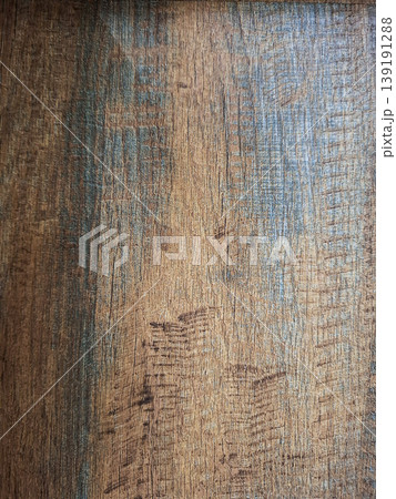 The background features a weathered brown wood surface with visible grain and scratches. Subtle blue paint remnants add detail for a rustic look. The wood gives a sense of age and character. The background features a weathered brown wood surface with visible grain and scratches. Subtle blue paint remnants add detail for a rustic look. The wood gives a sense of age and character. 139191288