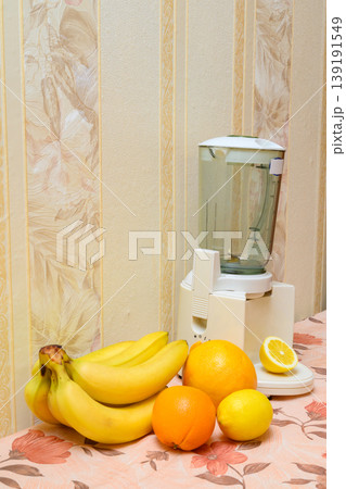 kitchen blender with fruits on the countertop in a cozy interior 139191549