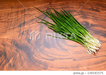 bunch of fresh green onions on a wooden table surface bunch of fresh green onions on a wooden table surface 139191575