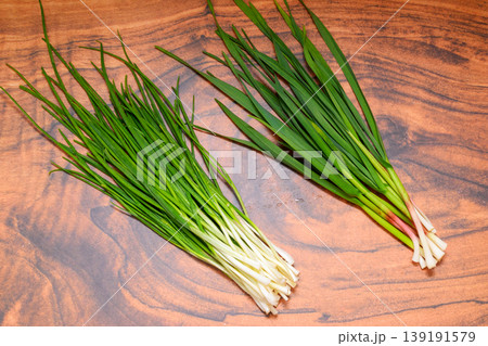 bunches of green onions and garlic on a dark wooden background bunches of green onions and garlic on a dark wooden background 139191579