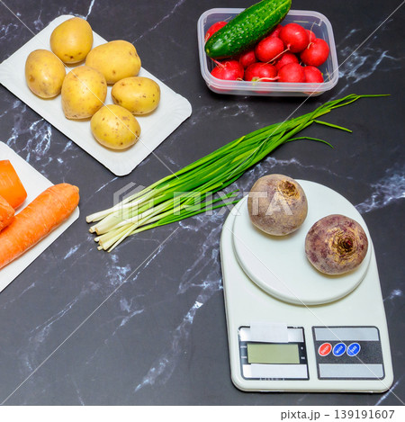 top view of kitchen scales with beets surrounded by carrots, potatoes and radishes top view of kitchen scales with beets surrounded by carrots, potatoes and radishes 139191607
