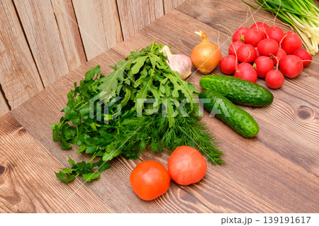 angled view of fresh tomatoes, cucumbers, radishes and thick greens on a wooden table angled view of fresh tomatoes, cucumbers, radishes and thick greens on a wooden table 139191617