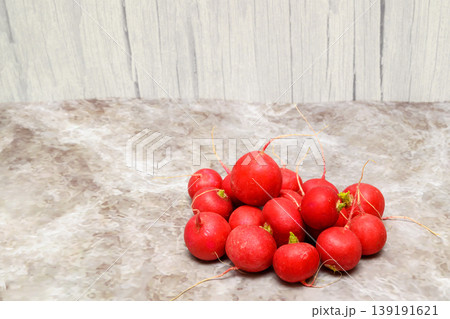 ripe red radishes on a marble background near a wooden wall ripe red radishes on a marble background near a wooden wall 139191621