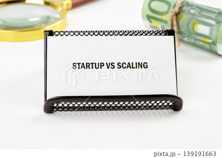 A white card with STARTUP VS SCALING sits in a black holder on a white surface A white card with STARTUP VS SCALING sits in a black holder on a white surface 139191663