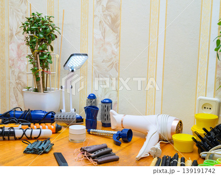 desk lamp illuminates hairdressing tools for creating a hairstyle on a wooden table desk lamp illuminates hairdressing tools for creating a hairstyle on a wooden table 139191742