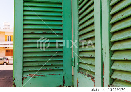 Close up of a green wooden louvered window shutter on an old building in Paphos, Ciprus. Selective focus and copy space. Close up of a green wooden louvered window shutter on an old building in Paphos, Ciprus. Selective focus and copy space. 139191764