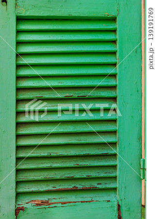 Close up of a green wooden louvered window shutter on an old building in Paphos, Ciprus. Selective focus and copy space. Close up of a green wooden louvered window shutter on an old building in Paphos, Ciprus. Selective focus and copy space. 139191769