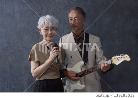 シニアのミュージシャン 男性のギタリストと女性のボーカル 黒背景 カメラ目線 シニアのミュージシャン 男性のギタリストと女性のボーカル 黒背景 カメラ目線 139193018
