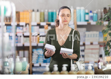 Middle-aged woman customer choosing pills in box in drugstore 139194210