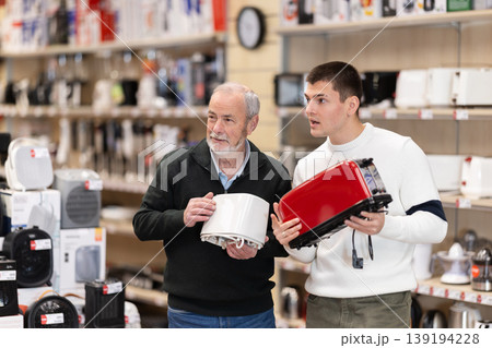 Eldery and young man choosing toaster Eldery and young man choosing toaster 139194228