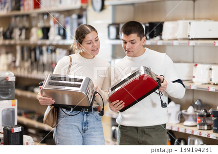 Couple customer inspect product range and selects toaster Couple customer inspect product range and selects toaster 139194231