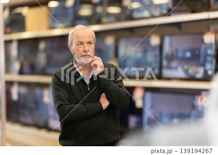 man stands near the TV sets in a store 139194267