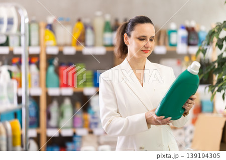 Adult woman buyer chooses detergent in store 139194305