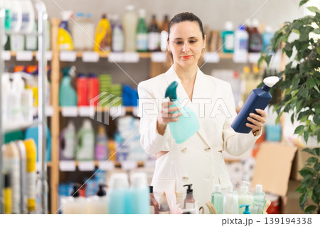Adult woman chooses cleaning spray in store 139194338