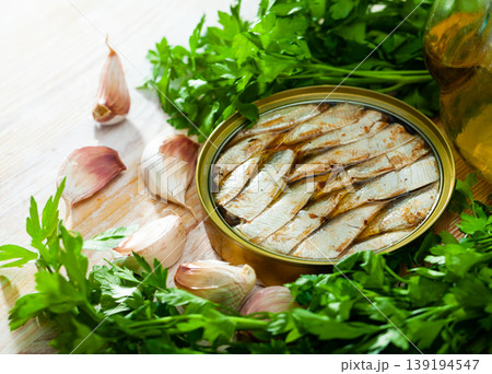 Canned small sardines in oil on background with greens Canned small sardines in oil on background with greens 139194547