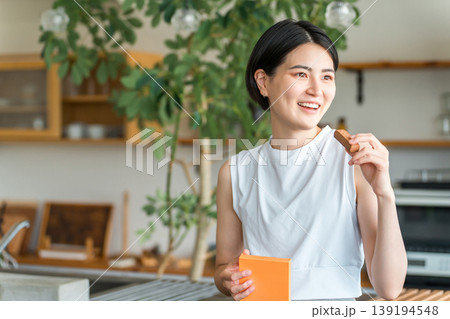 プロテインバー・栄養バーを食べるヨガウェア姿の若いアジア人女性 プロテインバー・栄養バーを食べるヨガウェア姿の若いアジア人女性 139194548