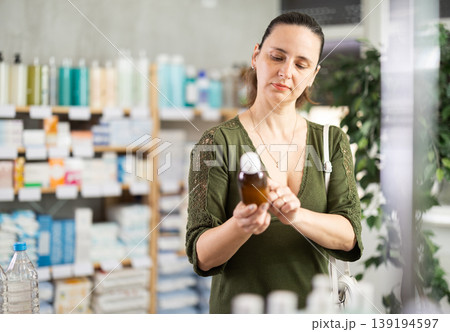 Woman are busy choosing antitussive suryp at pharmacy Woman are busy choosing antitussive suryp at pharmacy 139194597