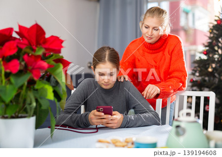 Girl sitting with phone and ignoring her mother 139194608