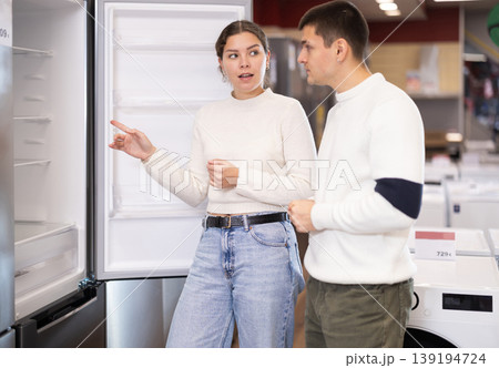 Couple choosing a refrigerator in an equipment store Couple choosing a refrigerator in an equipment store 139194724