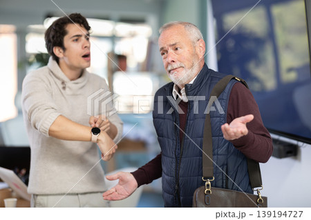 Young man scolding elderly male colleague for being late to office Young man scolding elderly male colleague for being late to office 139194727