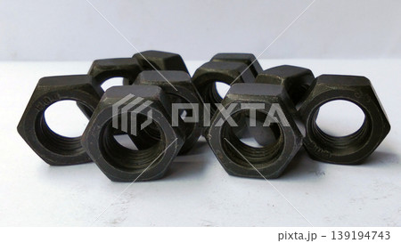 The dark colored hexagonal nut is seen close up against the white background. 139194743