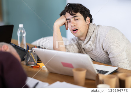 Tired elderly and young male colleagues fall asleep while working Tired elderly and young male colleagues fall asleep while working 139194778