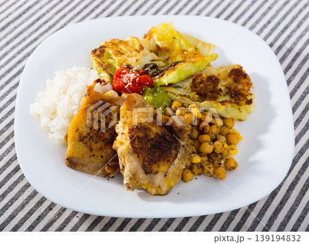 Chicken thighs with cabbage leaves in batter, cheakpea and rice at plate 139194832