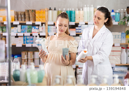 Pregnant woman choosing cream with help of pharmacist Pregnant woman choosing cream with help of pharmacist 139194848